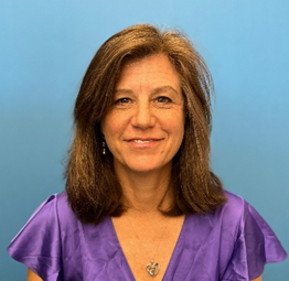 Portrait picture of Melinda Doring wearing a purple shirt with a blue background. 