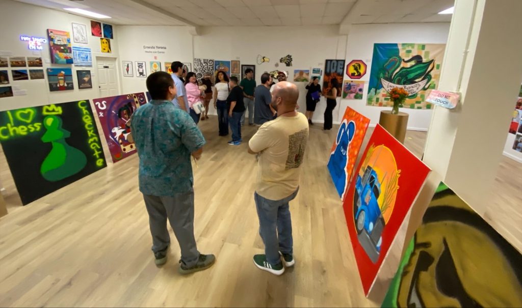 People standing and looking at art pieces inside a gallery
