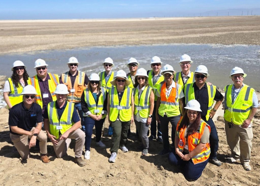 Group picture of the SSMP team wearing safety vests and white hard hats