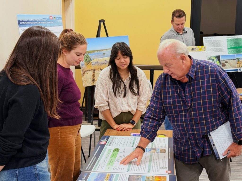 A resident looking at printed informational posters about the Imperial Streams and Salton Sea Aquatic Ecosystem Restoration Feasibility Study 