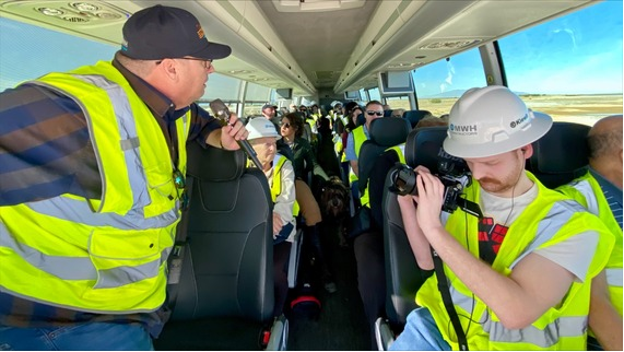 Mario Llanos describing the different project features using a microphone in the bus and guide the tour at the SCH.